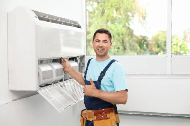 Klima kapalı duran erkek teknisyen