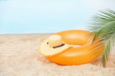 Renkli şişme halka ve kum üstünde şapka. Beach nesne