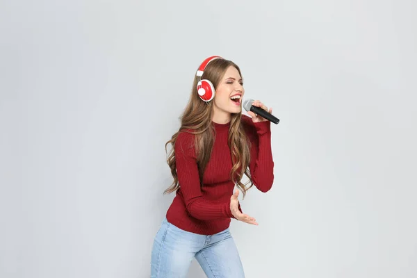 Νεαρή Γυναίκα Τραγουδάει Στο Μικρόφωνο Στο Χρώμα Φόντου Χριστουγεννιάτικη Μουσική — Φωτογραφία Αρχείου
