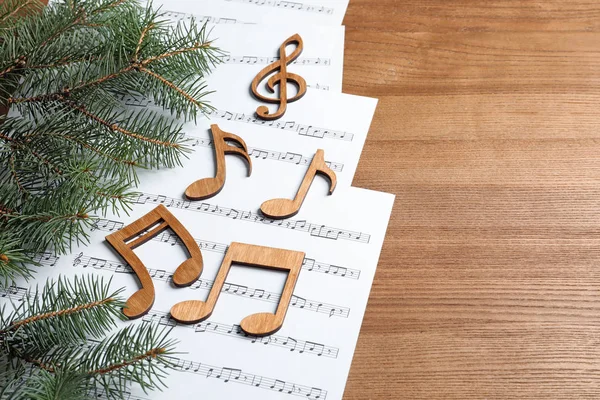Composition with music sheets and notes on wooden background. Christmas songs concept