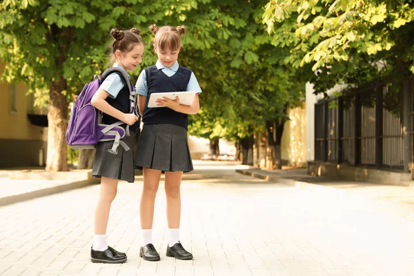 Små Flickor Eleganta Skoluniform Med Tablett Utomhus — Stockfoto