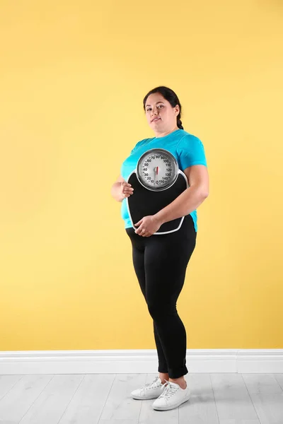 Избыточный Вес Женщины Спортивной Одежде Весами Рядом Цветной Стеной — стоковое фото