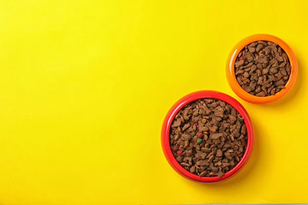 鉢色の背景上の犬と猫のための食糧 ペットの世話 — ストック写真