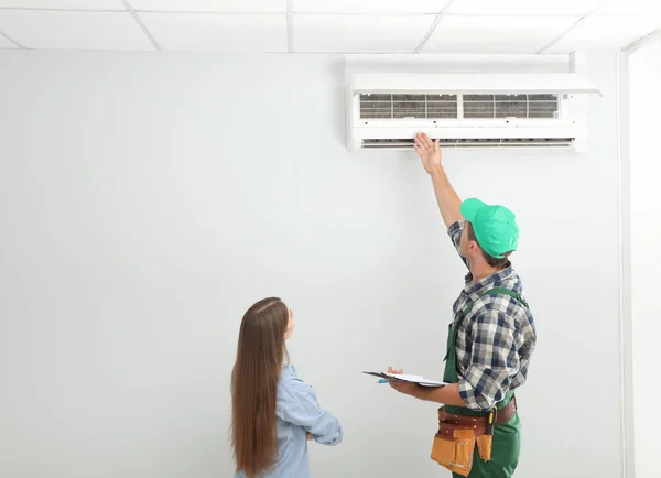 Techniker Spricht Mit Frau Über Klimaanlage Innenräumen — Stockfoto