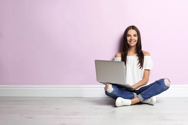 Jeune Femme Avec Ordinateur Portable Moderne Assis Près Mur Couleur — Photo