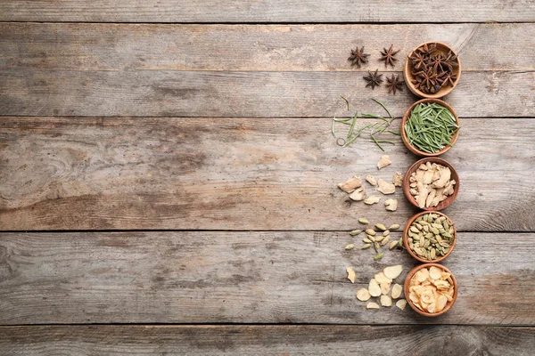 Ahşap arka plan üzerinde farklı Aromatik baharatlar ile düz yatıyordu kompozisyon