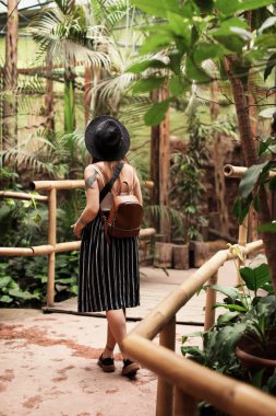 Güzel yeşil parkta yürüyen genç kadın