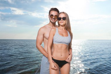 Genç adam ve onun güzel kız arkadaşı bikini yatta. Mutlu çift tatilde