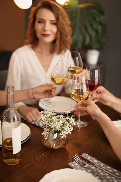 Young people with glasses of delicious wine at table