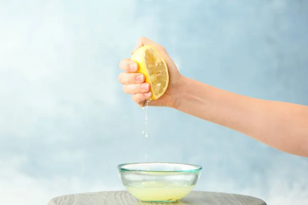 Jovem Mulher Espremendo Suco Limão Tigela Fundo Cor — Fotografia de Stock