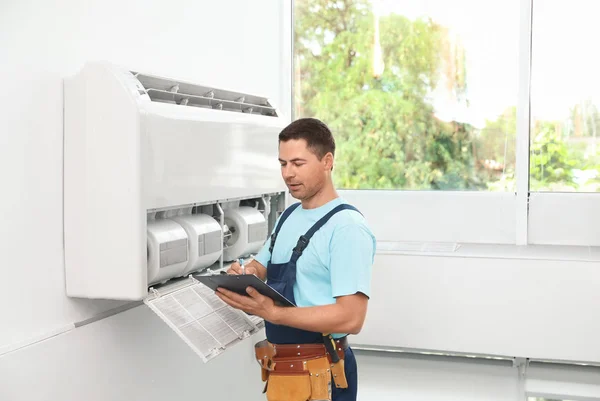 Techniker Mit Klemmbrett Der Nähe Von Klimaanlage Innenräumen — Stockfoto