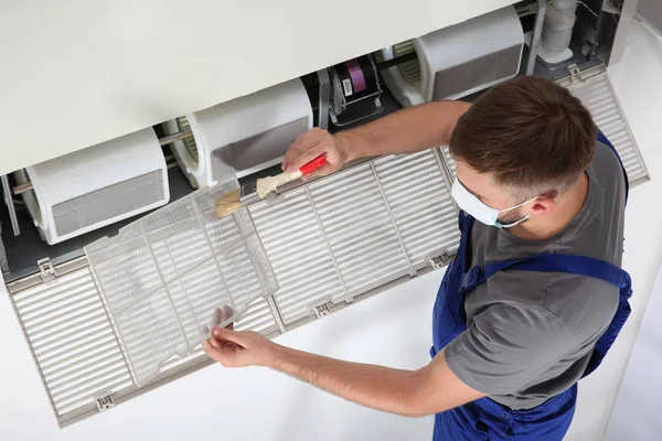 Young Male Technician Cleaning Air Conditioner Indoors — Stock Photo, Image