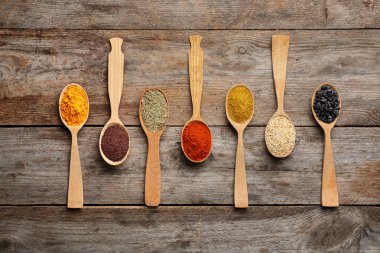 Ahşap zemin üzerine kaşık içinde farklı Aromatik baharatlar ile düz yatıyordu kompozisyon
