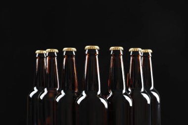 Birçok koyu arka plan üzerinde bira şişesi
