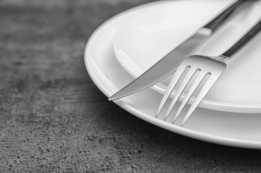 Boş dishware ve çatal bıçak takımı gri arka plan üzerinde görünümü kapatın. Tablo ayarı