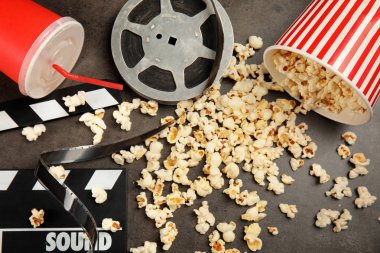 Patlamış mısır, film reel ve Klaket gri arka plan üzerinde düz yatıyordu kompozisyonu