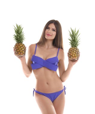 Beyaz arka plan üzerinde ananas ile bikinili seksi genç kadın