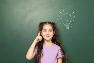 Küçük okul çocuğun yanında kara tahta çizim ampul ile