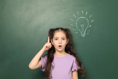 Küçük okul çocuğun yanında kara tahta çizim ampul ile