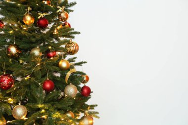 Peri ışıkları ve beyaz arka plan üzerinde şenlikli dekor ile güzel Noel ağacı