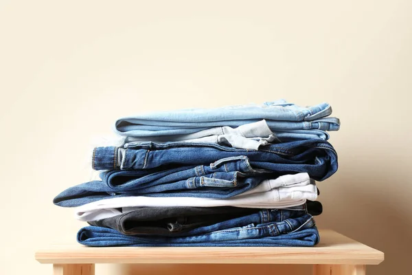 Stapel Van Verschillende Jeans Tafel Tegen Een Achtergrond Met Kleur — Stockfoto