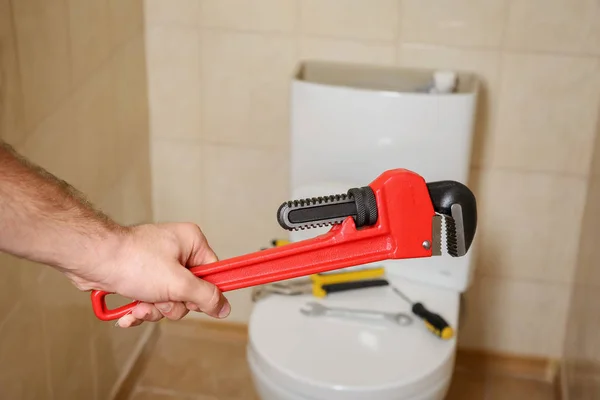 Plumber Holding Pipe Wrench Toilet Indoors Closeup — Stock Photo, Image