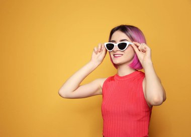 Son moda saç renk arka plan karşı güneş gözlüğü takmış olan kadın