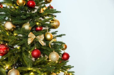 Peri ışıkları ve beyaz arka plan üzerinde şenlikli dekor ile güzel Noel ağacı