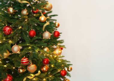 Peri ışıkları ve beyaz arka plan üzerinde şenlikli dekor ile güzel Noel ağacı