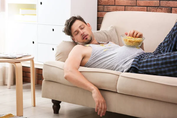 Homem Preguiçoso Com Tigela Batatas Fritas Dormindo Sofá Casa — Fotografia de Stock