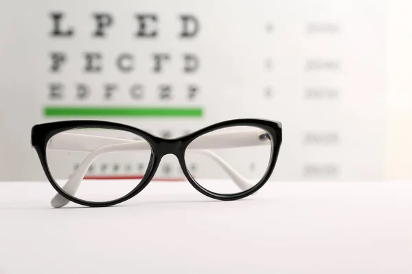 Brille Mit Korrekturgläsern Auf Tisch Gegen Augentafel — Stockfoto