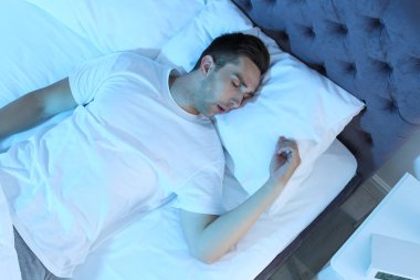 Gece, en iyi manzaraya yatakta uyuyan genç adam