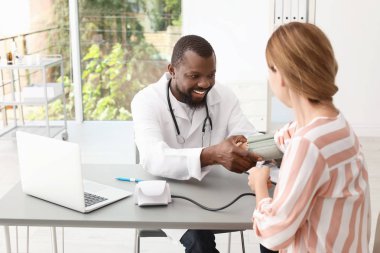 Genç Afrikalı-Amerikalı doktor hastane hastanın kan basıncı kontrol