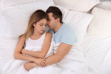 Genç çift yatakta evde yumuşak yastık uyku