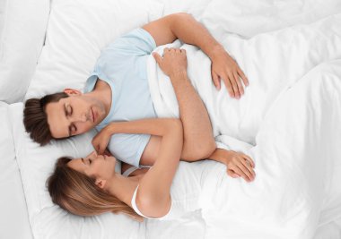 Genç çift yatakta evde yumuşak yastık uyku