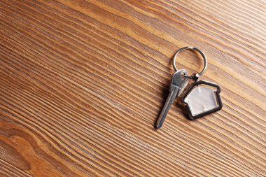 Biblo evin ahşap arka plan üzerinde şeklinde anahtarla. Emlak Hizmetleri