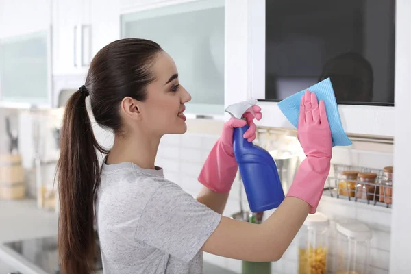 Genç Kadın Evde Bez Ile Mikrodalga Fırın Temizleme — Stok fotoğraf