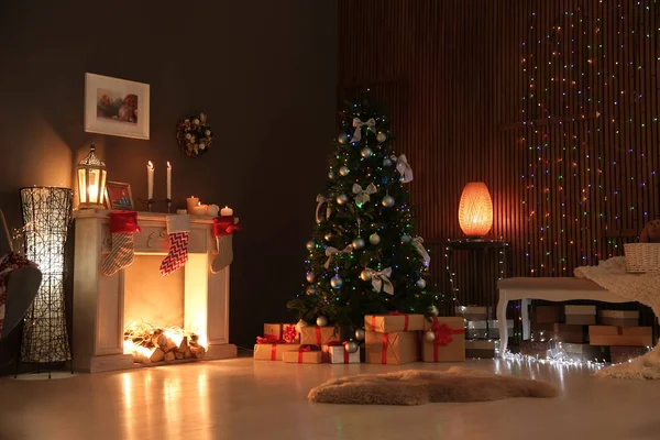Stylish living room interior with decorated Christmas tree at night