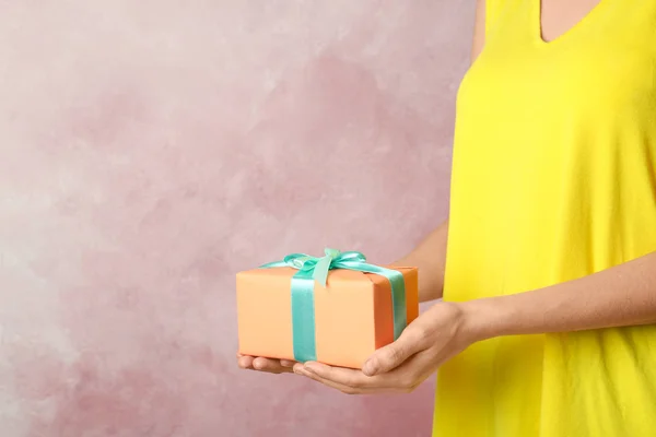 女子手持精美包装礼品盒彩色背景 — 图库照片