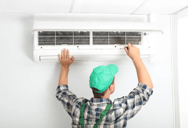 Técnico Masculino Fixando Condicionado Moderno Dentro Casa — Fotografia de Stock