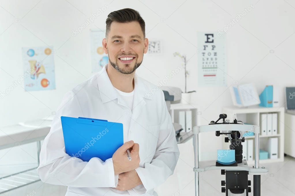 Ophthalmologist with modern equipment and clipboard in clinic