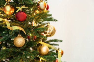 Peri ışıkları ve renk arka plan üzerinde şenlikli dekor ile güzel Noel ağacı