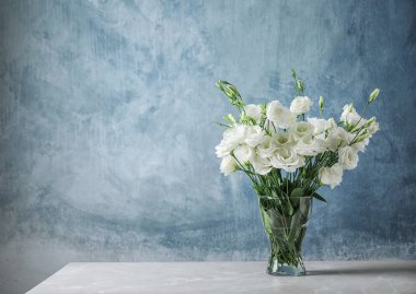 Renk arka plan karşı masada güzel Eustoma çiçekli vazo