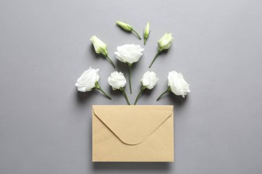 Güzel Eustoma çiçekler ve gri arka plan üzerinde zarf