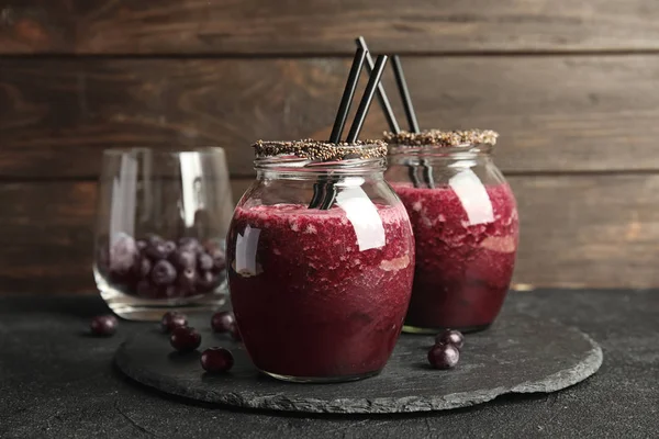 Frascos Suco Açaí Delicioso Com Palhas Coquetel Mesa Escura Contra — Fotografia de Stock