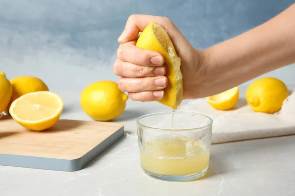 Žena Mačkání Citronu Sklenice Stole — Stock fotografie