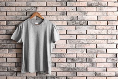 Askı ile boş t-shirt tuğla duvar üzerine. Mockup tasarım için