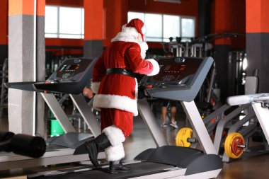 Otantik Noel Baba modern spor salonunda treadmill eğitim