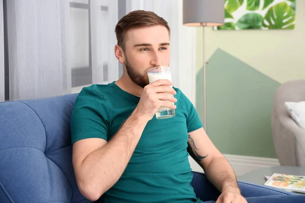 在家喝可口的牛奶的年轻人 — 图库照片