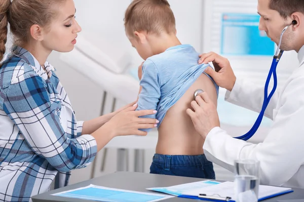 stock image Doctor examining coughing little boy at clinic